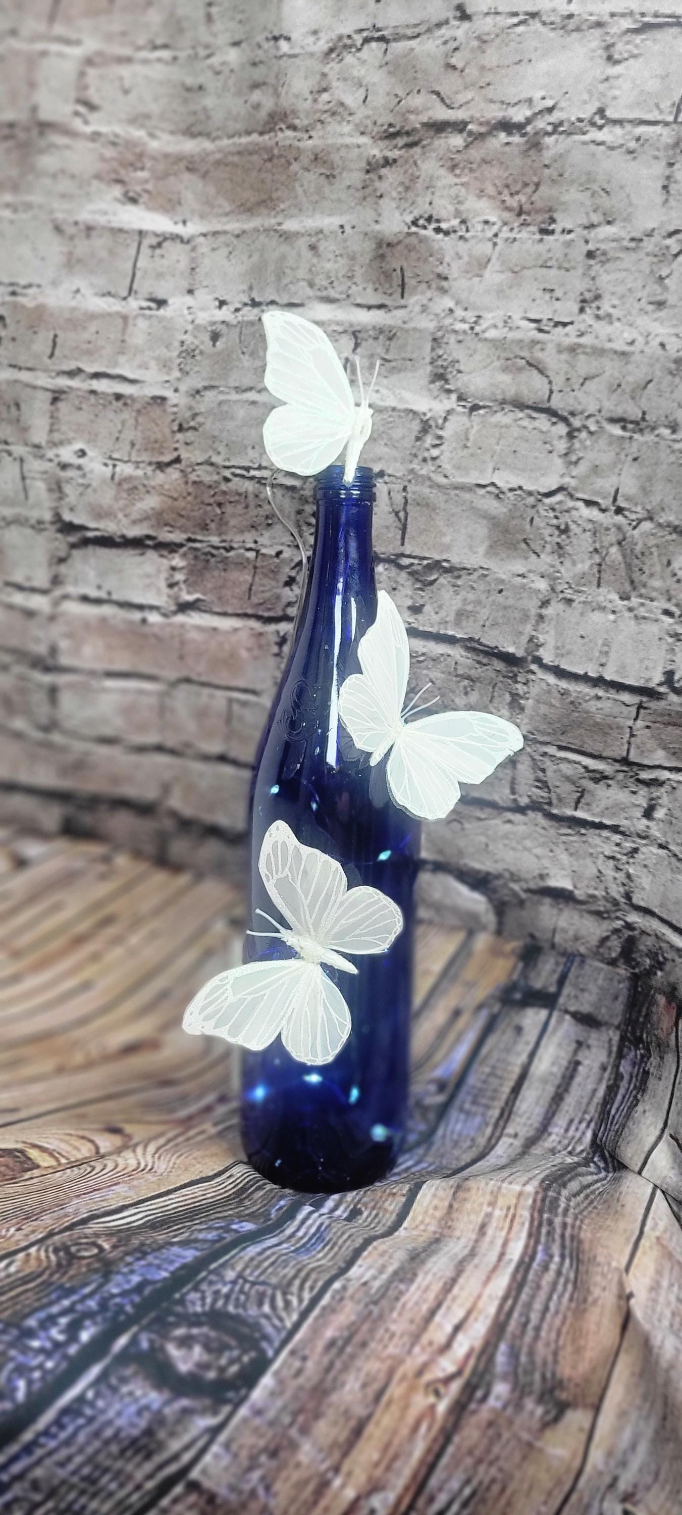 Cobalt blue wine bottle electric LED lights with white butterflies table decor centerpiece
